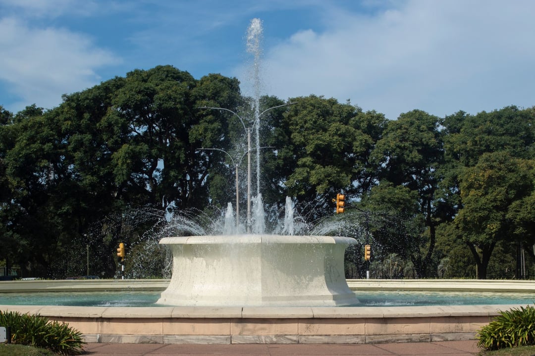 Fuente con chorros de agua en el Parque Batlle, con la arboleda del parque detrás
