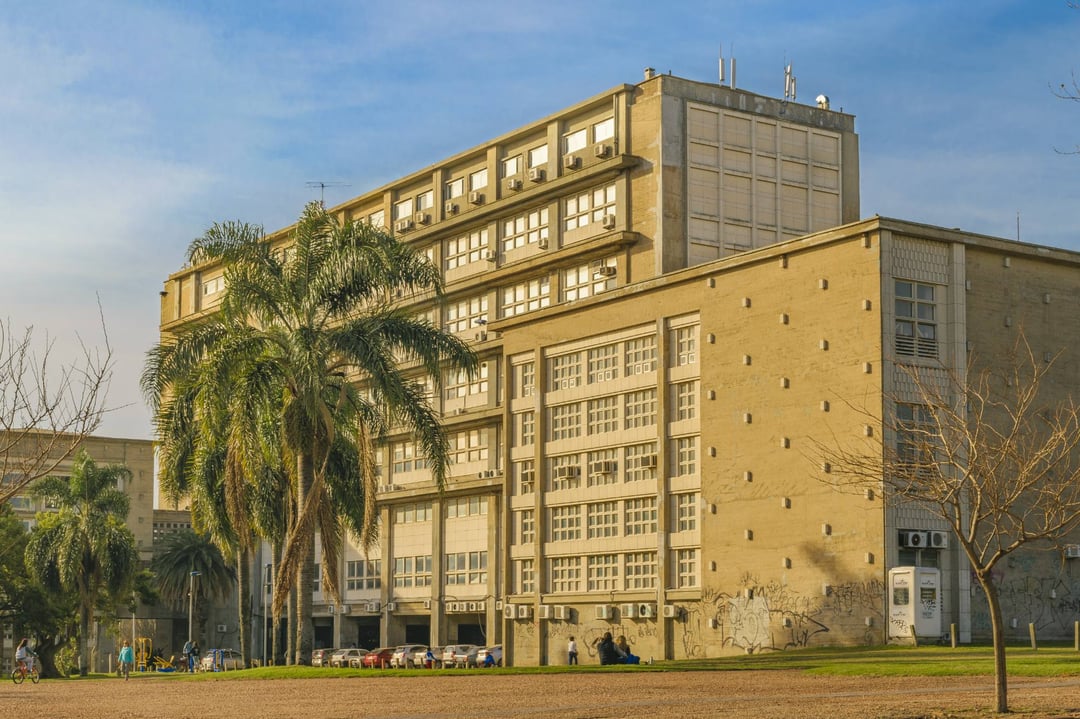 Edificio de la Facultad de Ingeniería, de Julio Vilamajó, con palmeras y el césped del parque al frente