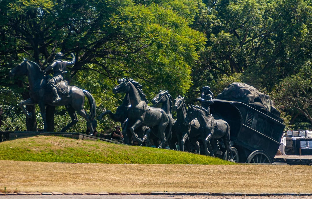 Monumento La Diligencia, de José Belloni, con los caballos de bronce y el carruaje entre los árboles del Prado