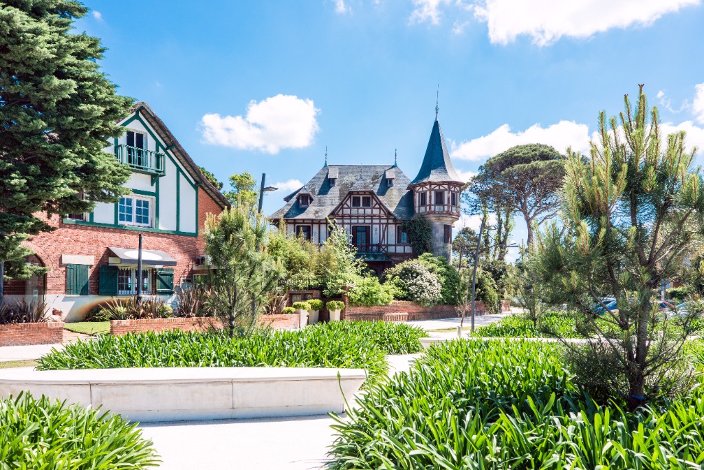Casas de ladrillo y tejado con torre, jardín y pinos en Carrasco
