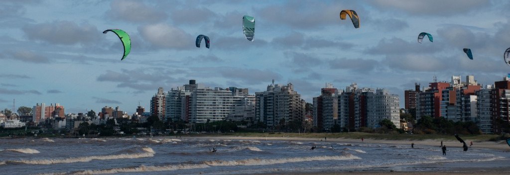 Playa de Malvín con cometas de kitesurf, el río y los edificios de la rambla